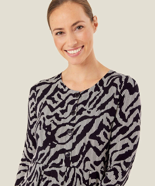 Masai Nilana tulip dress in black kyanite graphic pattern. Round neckline, long sleeves, pleating details and side pockets. Button up placket