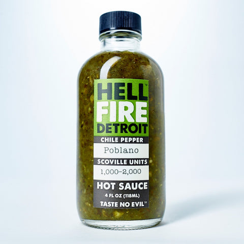 4 fluid ounce glass bottle with a black twist off cap filled with hot sauce. Has green, black, and white label with text, "Hell Fire Detroit, Chile Peppers, Poblano, Scoville Units 1,000 - 2,000 Hot Sauce. "