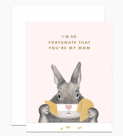 A bunny is opening a fortune cookie with a heart on the paper.  Gold foiled letters above read "I'm so fortunate that you're my mom"