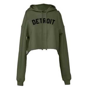 Ink Detroit Cropped Hoodie in green. Long sleeve, hooded sweatshirt in army green color with "Detroit" pritned across the chest. Cropped length with raw, rolled hem.