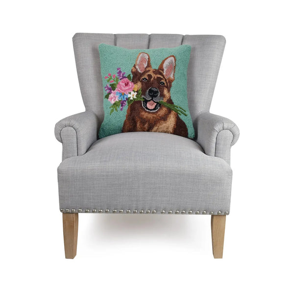 Seafoam green hooked wool pillow with a German Shepherd Dog holding flowers in its mouth on a chair