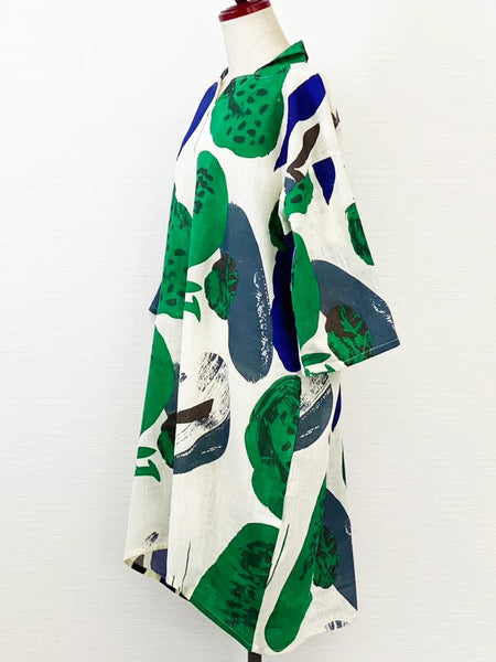 Natural white balloon shaped dress featuring oversized blue, green and black tropical print.