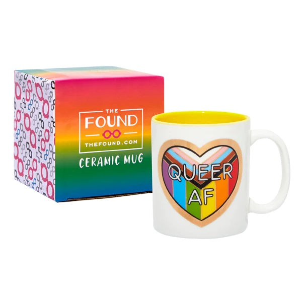 White mug with an LGBT pride flag shaped as a heart with the text "Queer AF".