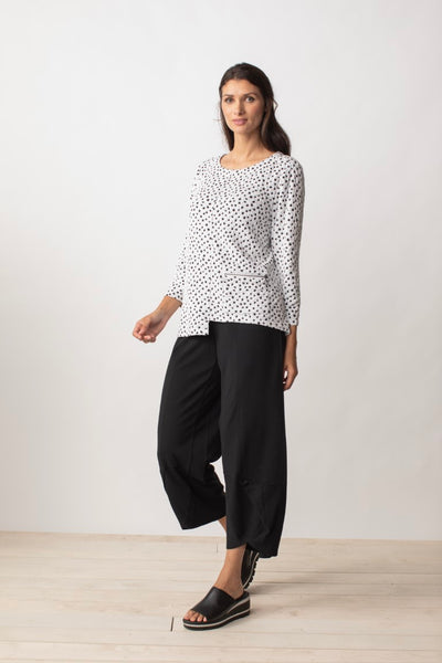 Liv by Habitat Speckled Dot Pullover in white. White tunic top with black dots scattered throughout. Round neck, cropped sleeves, asymmetrical hemline, zuppered pocket on front.