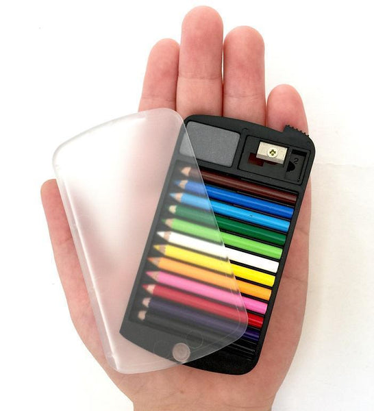 Hand holding a black case with clear rotating lid containing colored pencils, small eraser, and pencil sharpener.