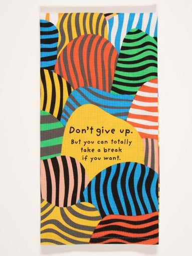 Screen printed dish towel composed of different colored blobs with stripes.  In the middle. there is a stripeless yellow blob that has text saying, "Don't give up, but you can totally ake a break if you want."