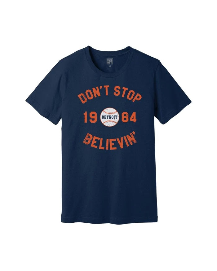 Ink Detroit Tigers Don't Stop Believing T0shirt. Navy Blue with 1984 and Don't Stop Believin' printed on chest in orange.  A baseball with "Detroit" is center in the design.