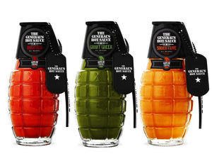 Three glass grenade-shaped bottles filled with different colored hot sauces.
